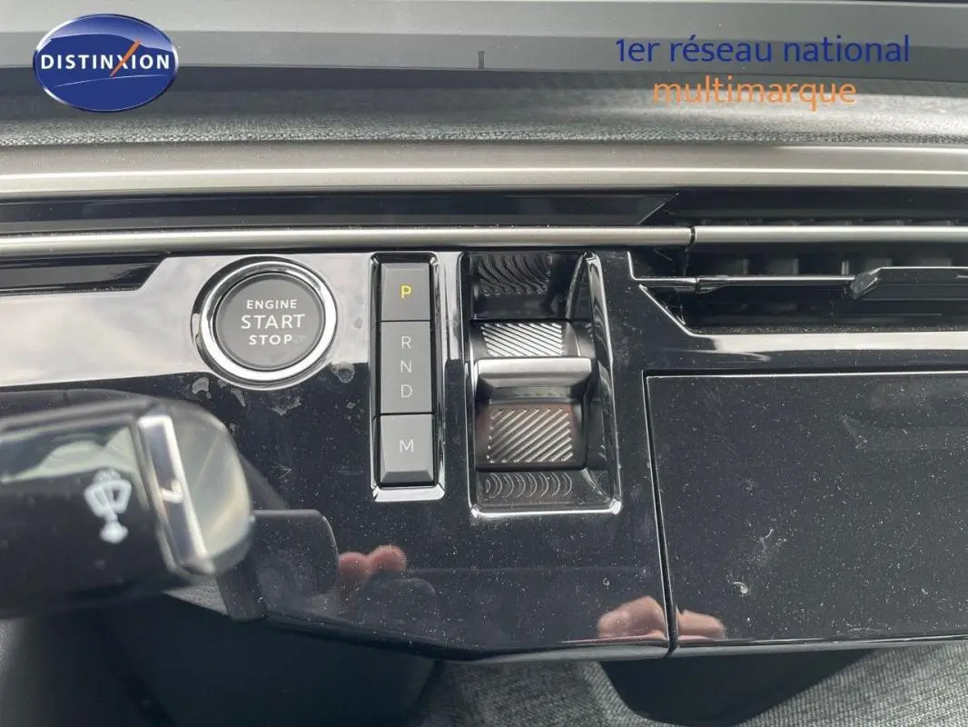 Détail intérieur du tableau de bord noir du Peugeot 3008 hybride 2025 avec bouton start/stop et commandes de boîte automatique.