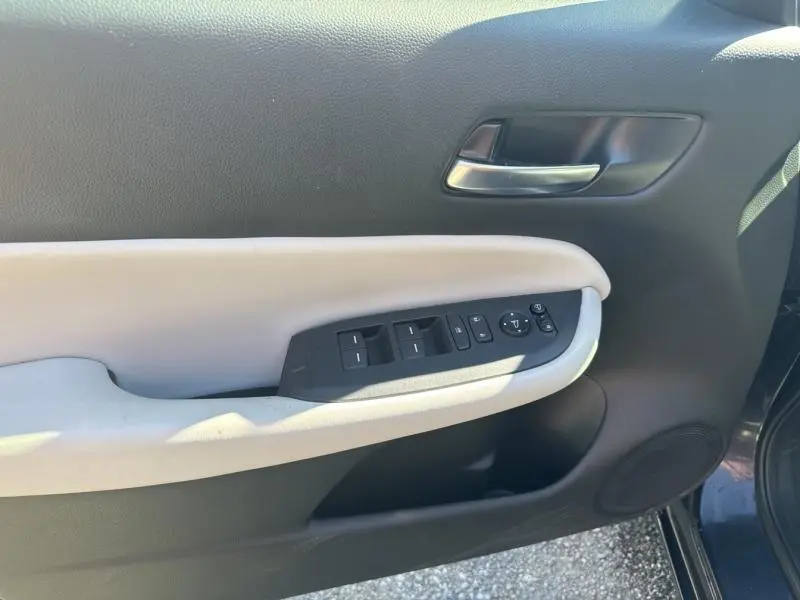 Vue rapprochée de la porte avant gauche de la Honda Jazz 2021 bleu nuit, avec commandes électriques et poignée argentée.