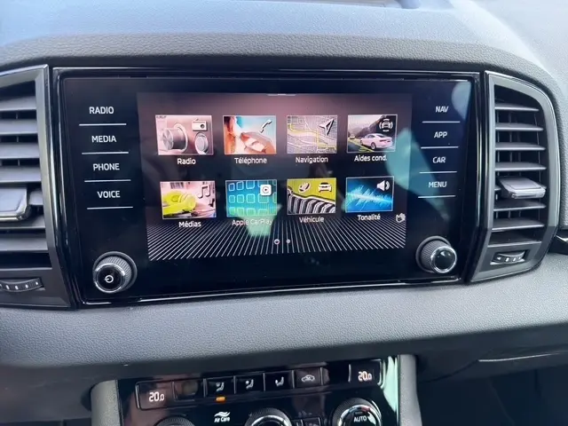 Écran tactile central du tableau de bord du Skoda Karoq 2025 noir, affichant les menus multimédias et navigation.