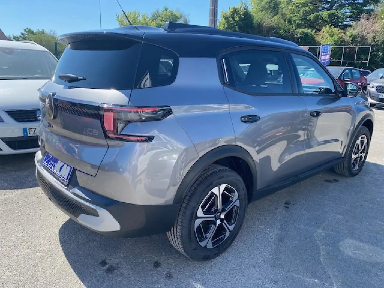Vue 3/4 arrière droite d'un Citroën C3 Aircross gris Mercury avec toit noir et jantes alliage 17 pouces.