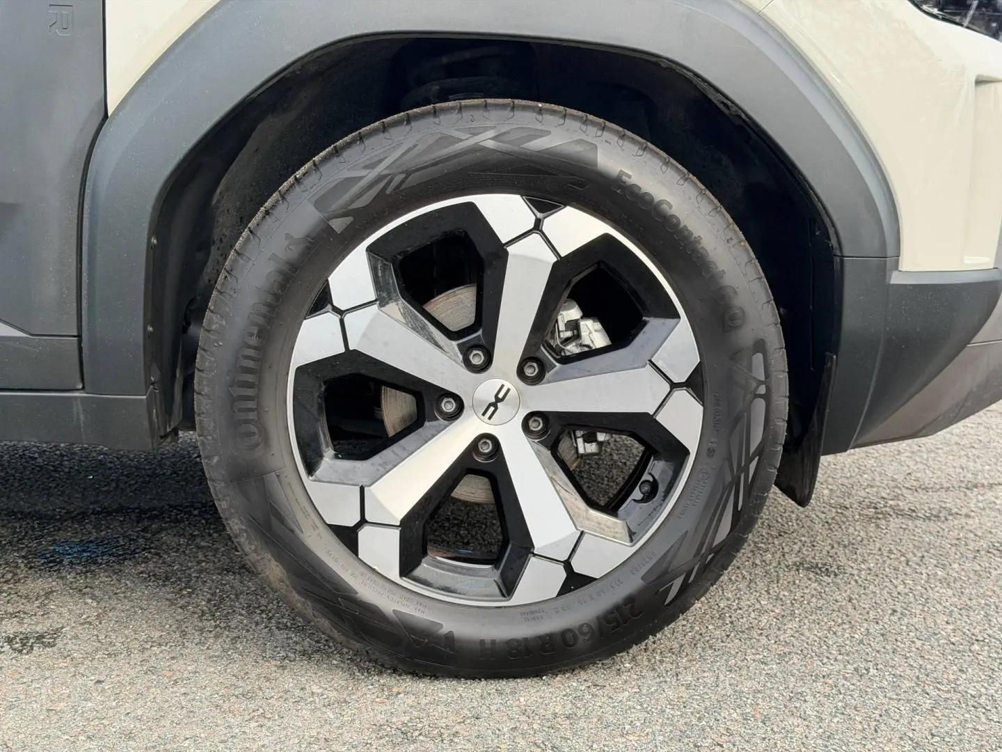 Gros plan sur la roue avant droite du Dacia Duster 2025 couleur Sandstone avec jante alu bicolore.