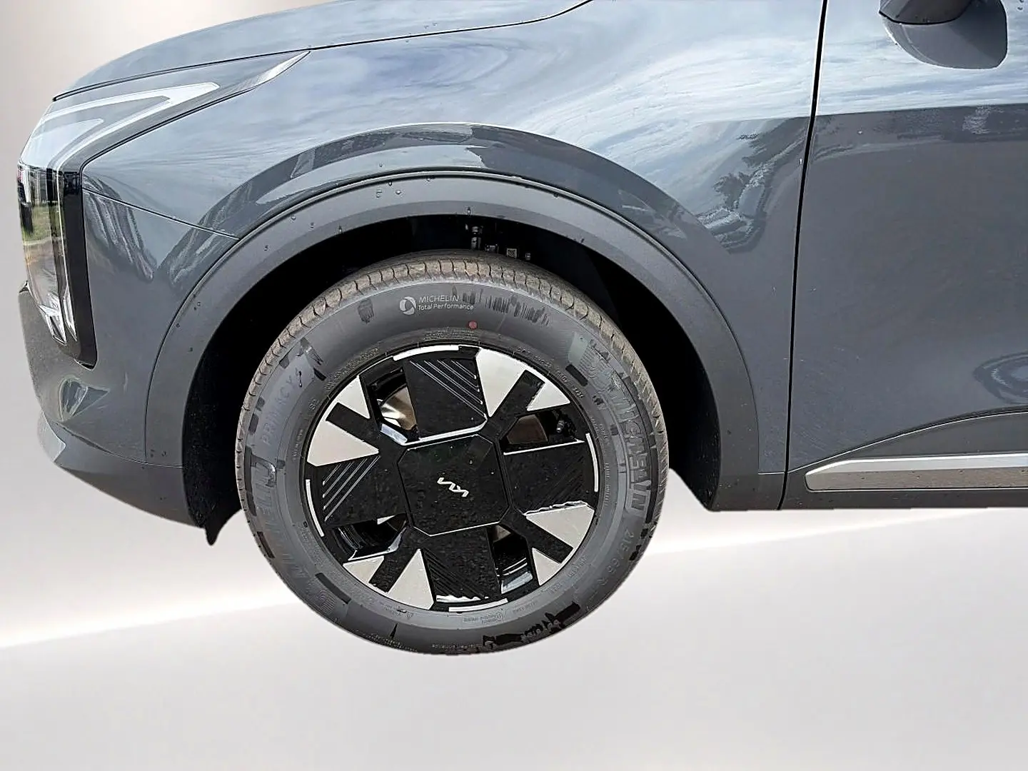 Gros plan sur la roue avant gauche du KIA Sportage gris eclipse, mettant en valeur la jante alu au design moderne.