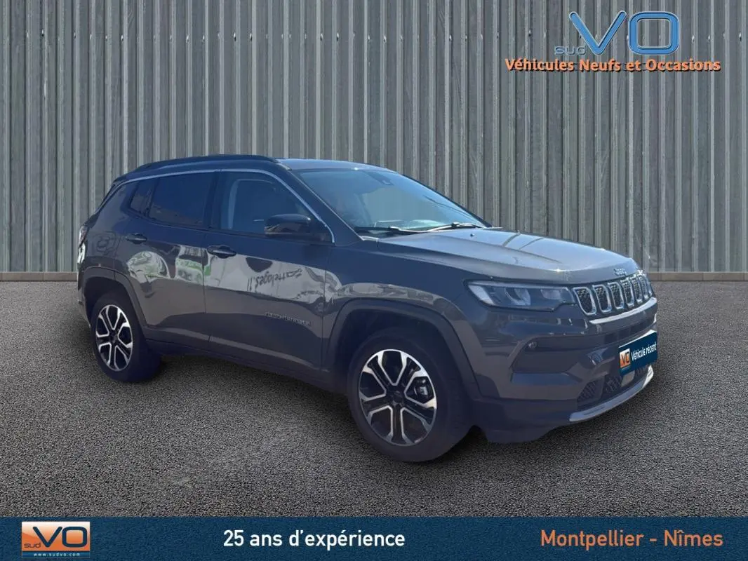 Jeep Compass gris 3/4 avant droit, SUV 2023 avec jantes 18 pouces et barres de toit visibles