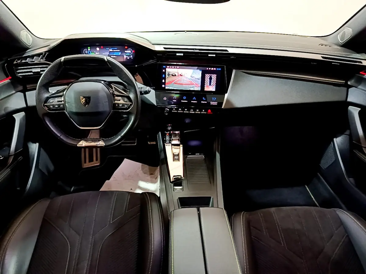 Intérieur noir de la Peugeot 308 PHEV 180 GT 2022, vue avant centrée sur tableau de bord et volant compact.
