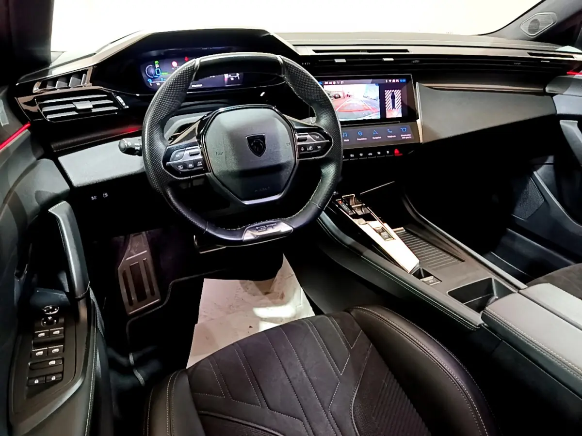 Intérieur Peugeot 308 PHEV 180 GT vu côté conducteur, tableau de bord moderne avec écran tactile et volant compact cuir.