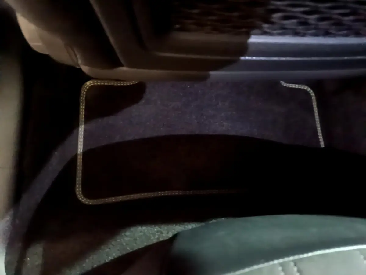 Tapis de sol noir avec surpiqûres beiges côté conducteur dans l'habitacle d'une Peugeot 308 PHEV 180 E-EAT8 GT blanche 2022.