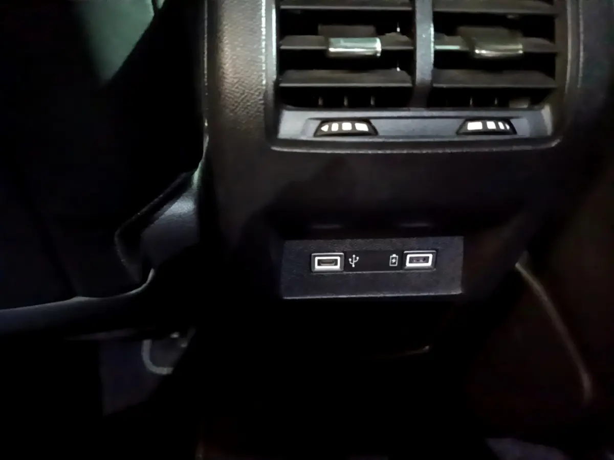 Prise USB double et ventilation arrière en gros plan dans l'habitacle noir d'une Peugeot 308 PHEV 180 E-EAT8 GT blanche