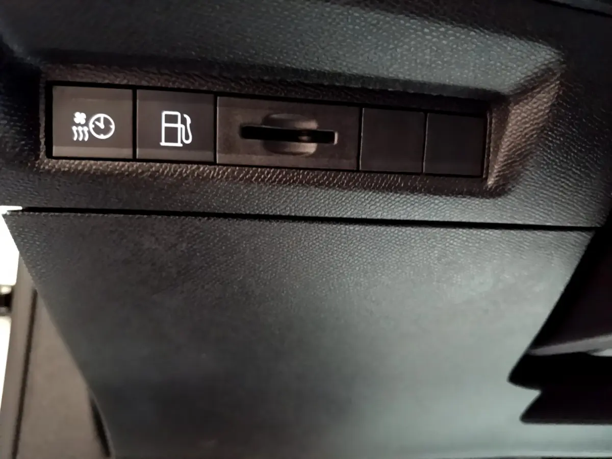 Gros plan sur les commandes de chauffage et carburant du tableau de bord d'une Peugeot 308 PHEV 180 E-EAT8 GT blanche.