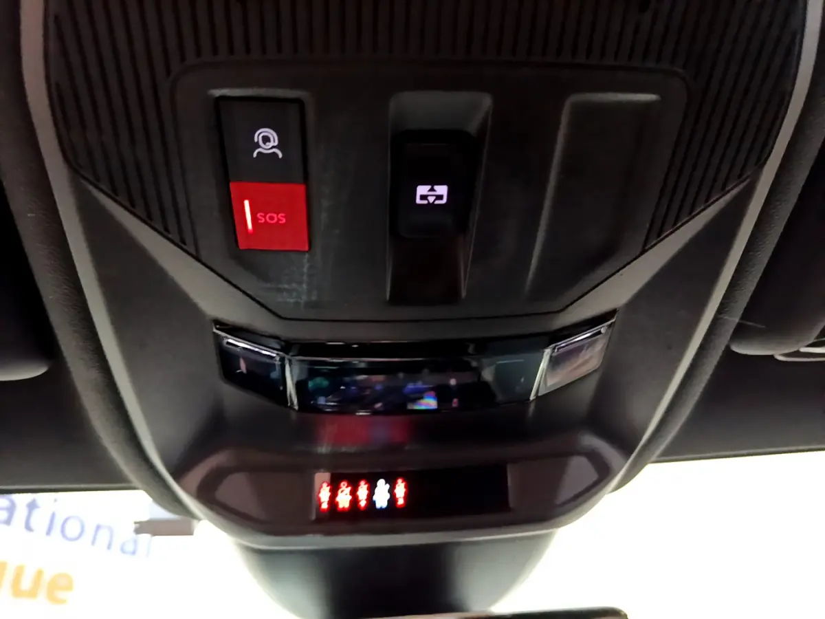 Vue en gros plan du plafonnier intérieur noir avec bouton SOS rouge et commande d'ouverture de toit sur Peugeot 308 PHEV blanc