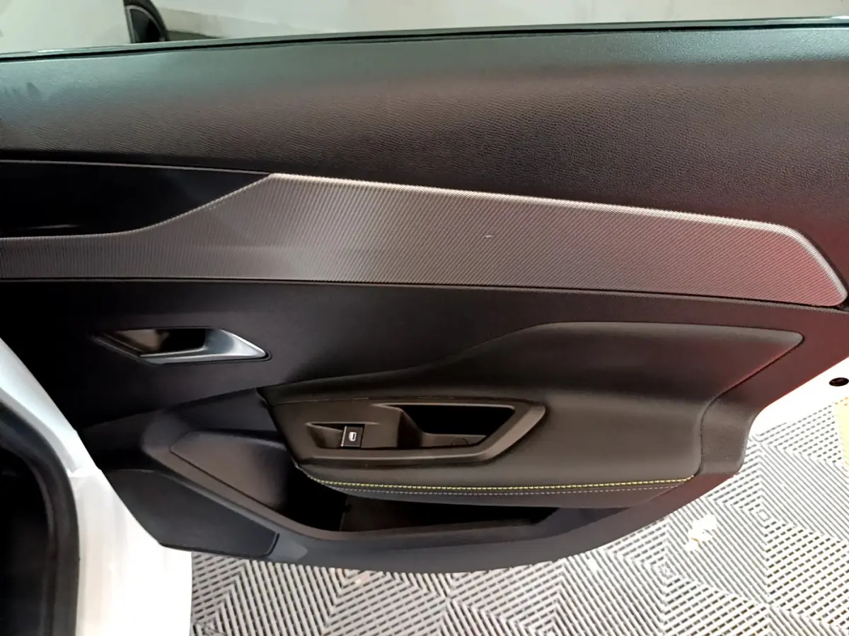 Vue intérieure côté gauche de la porte avant blanche d'une Peugeot 308 PHEV 180 E-EAT8 GT avec surpiqûres jaunes.