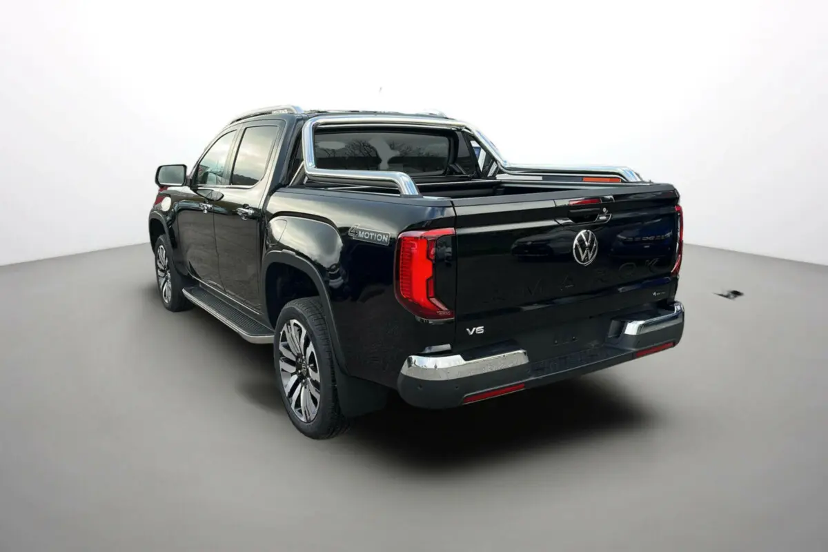 Volkswagen Amarok V6 noir vu 3/4 arrière droit avec arceaux inox et feux arrière LED distinctifs.