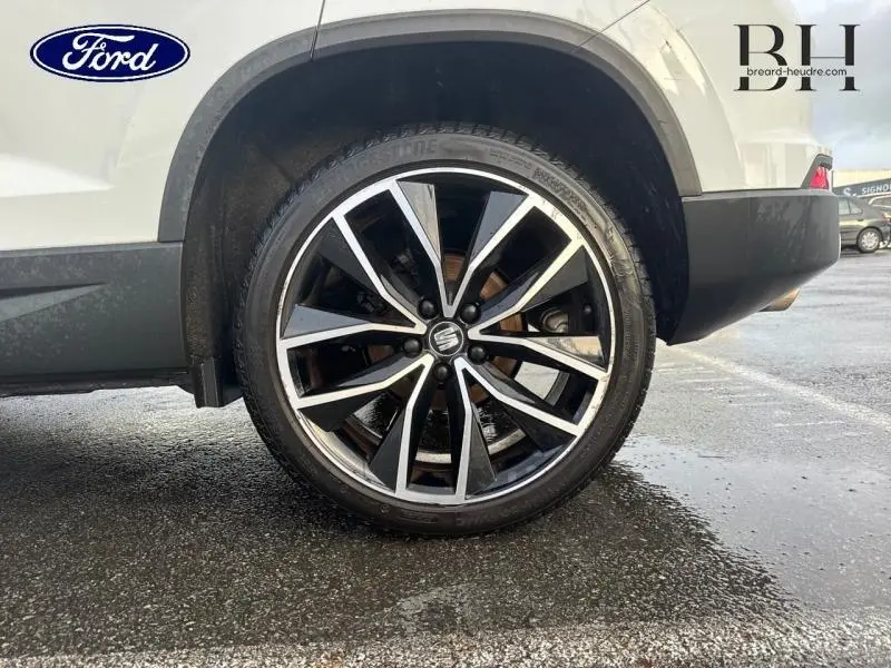 Gros plan sur la roue arrière droite du SEAT Ateca blanc Nevada Métal avec jante alliage noire et argent.