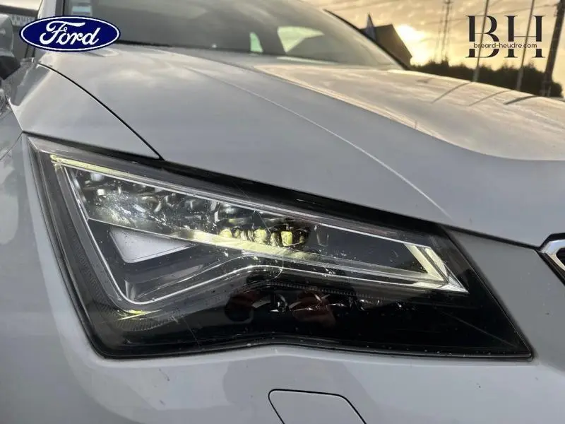 Gros plan sur le phare avant gauche du SEAT Ateca blanc Nevada Métal, soulignant son design anguleux et moderne.