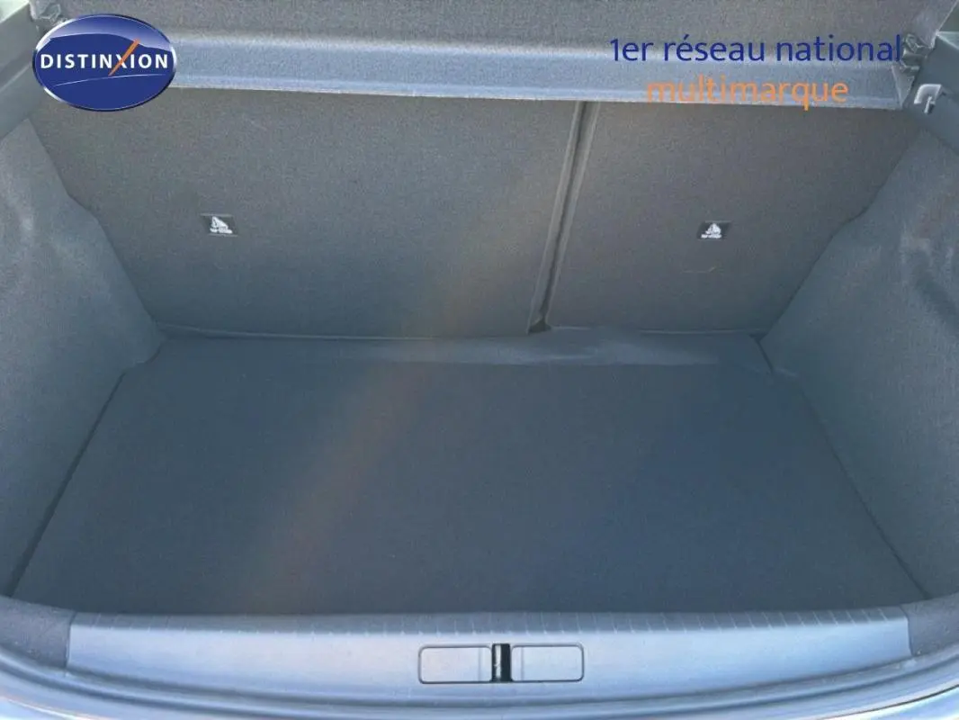 Vue intérieure du coffre spacieux et vide de la Peugeot 208 gris 1.2 Hybrid 2025, avec cache bagages visible.