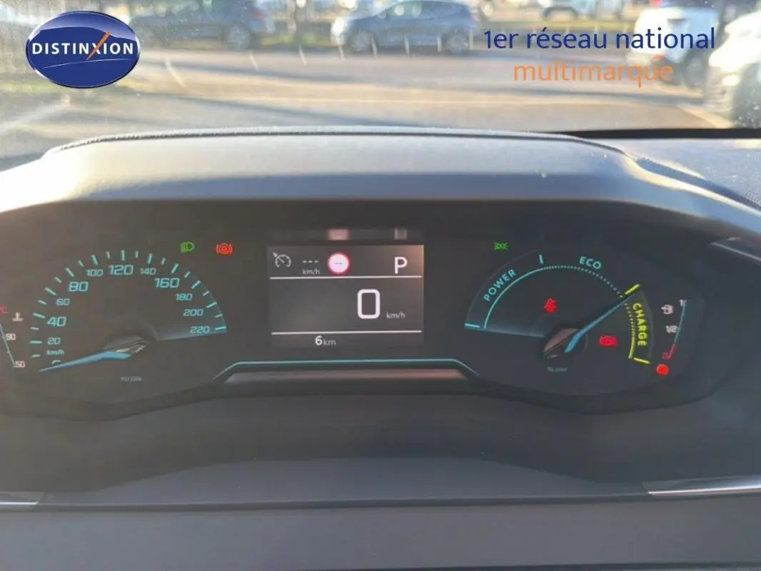 Vue rapprochée du tableau de bord numérique de la Peugeot 208 hybride 2025, affichant vitesse et indicateurs eco.