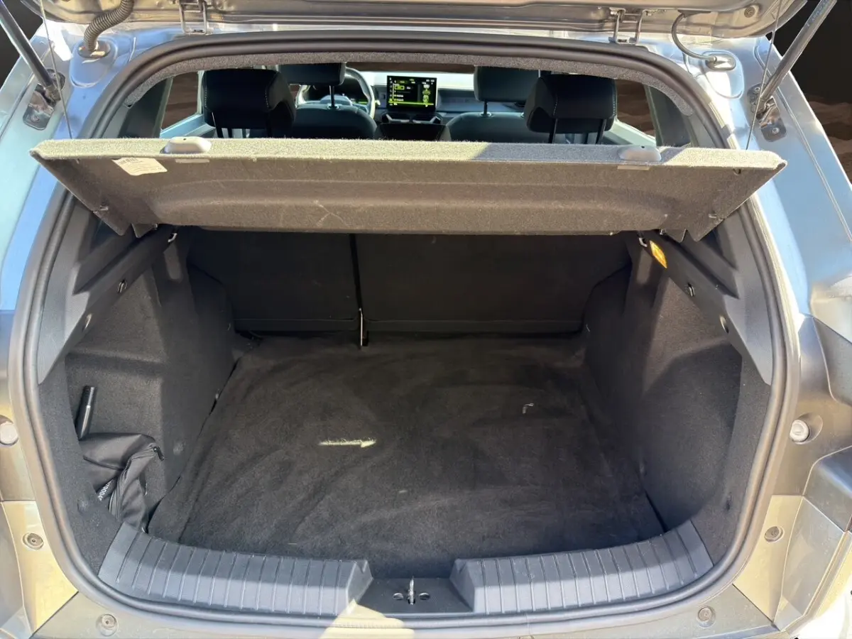 Coffre ouvert du Dacia Duster gris foncé, vue arrière montrant l'espace de chargement vide et la tablette de séparation.