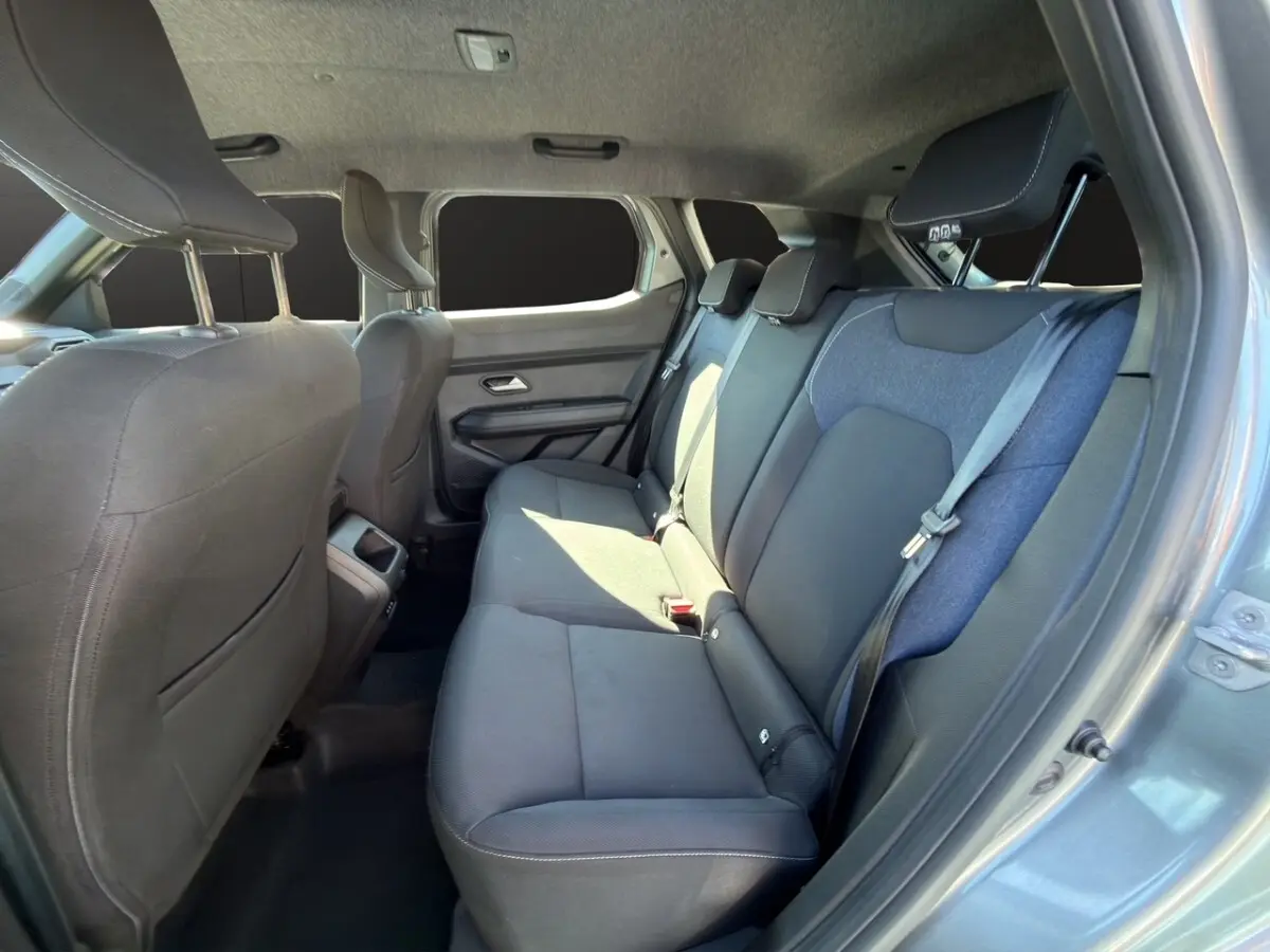 Vue intérieure côté droit sur la banquette arrière grise du Dacia Duster 2025 expression hybrid avec ceinture de sécurité.