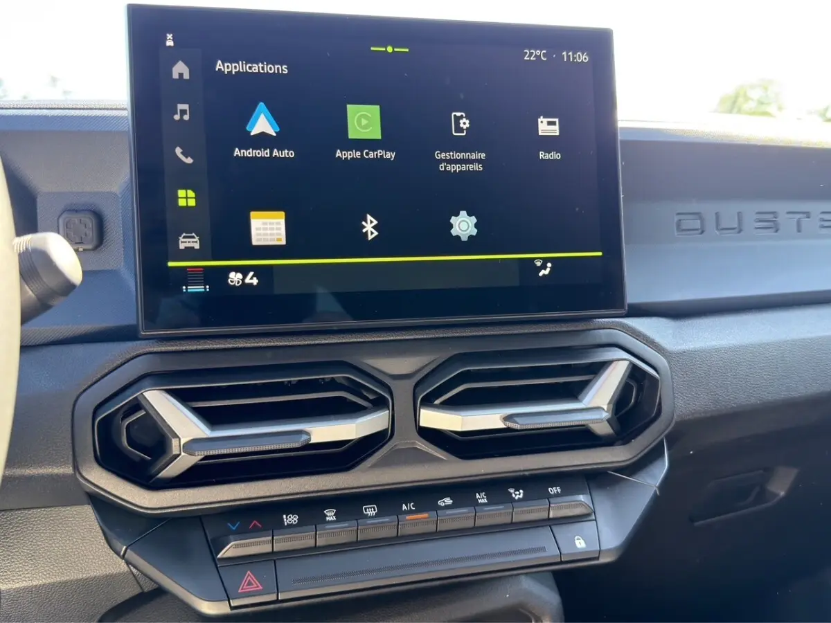 Vue rapprochée du tableau de bord du Dacia Duster gris foncé 2025, écran tactile avec Apple CarPlay et Android Auto.