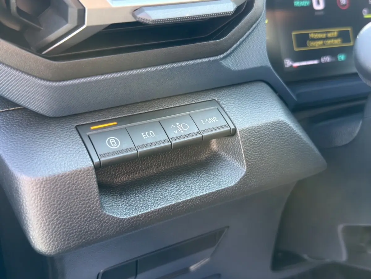 Gros plan sur les boutons de commande gris foncé du tableau de bord du Dacia Duster Expression Hybrid 140, côté conducteur.