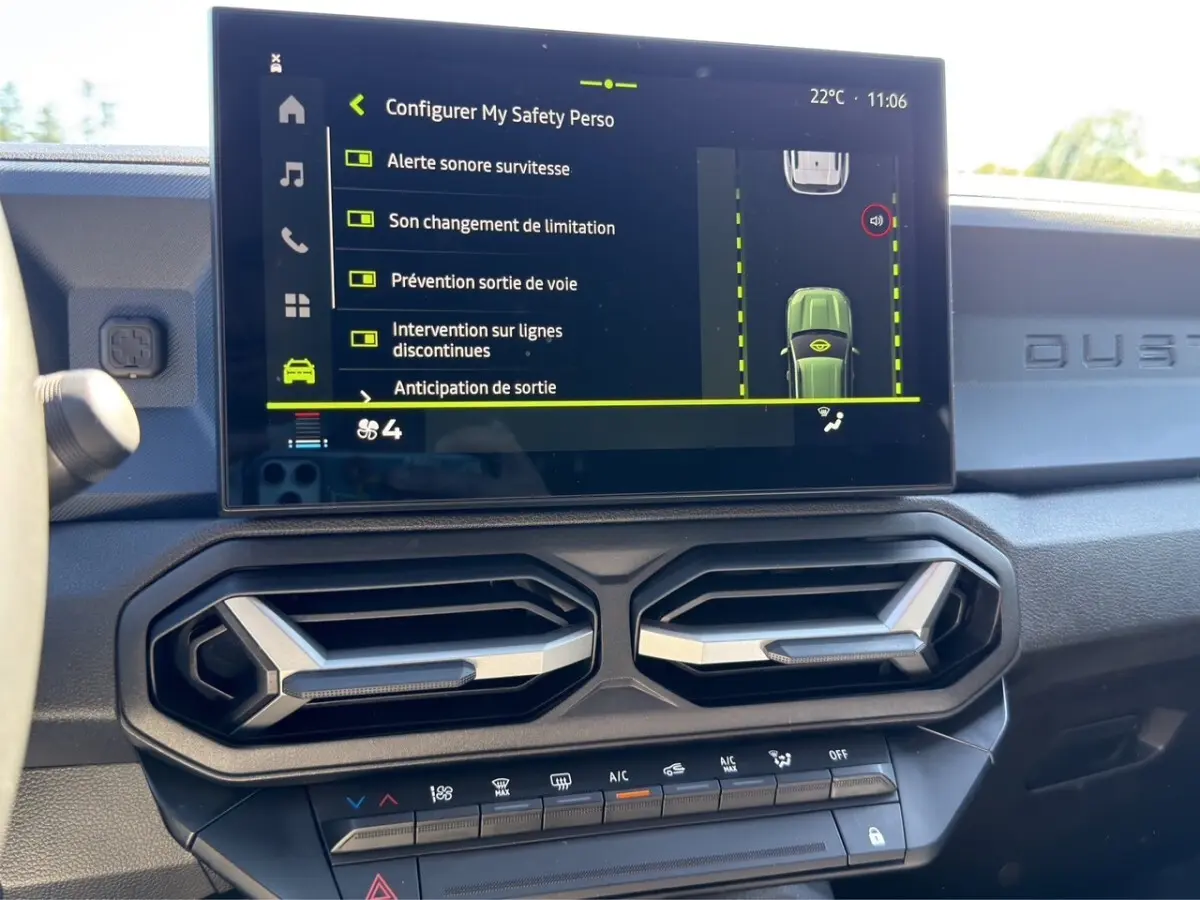 Vue intérieure du tableau de bord du Dacia Duster gris foncé, écran tactile affichant les aides à la conduite.