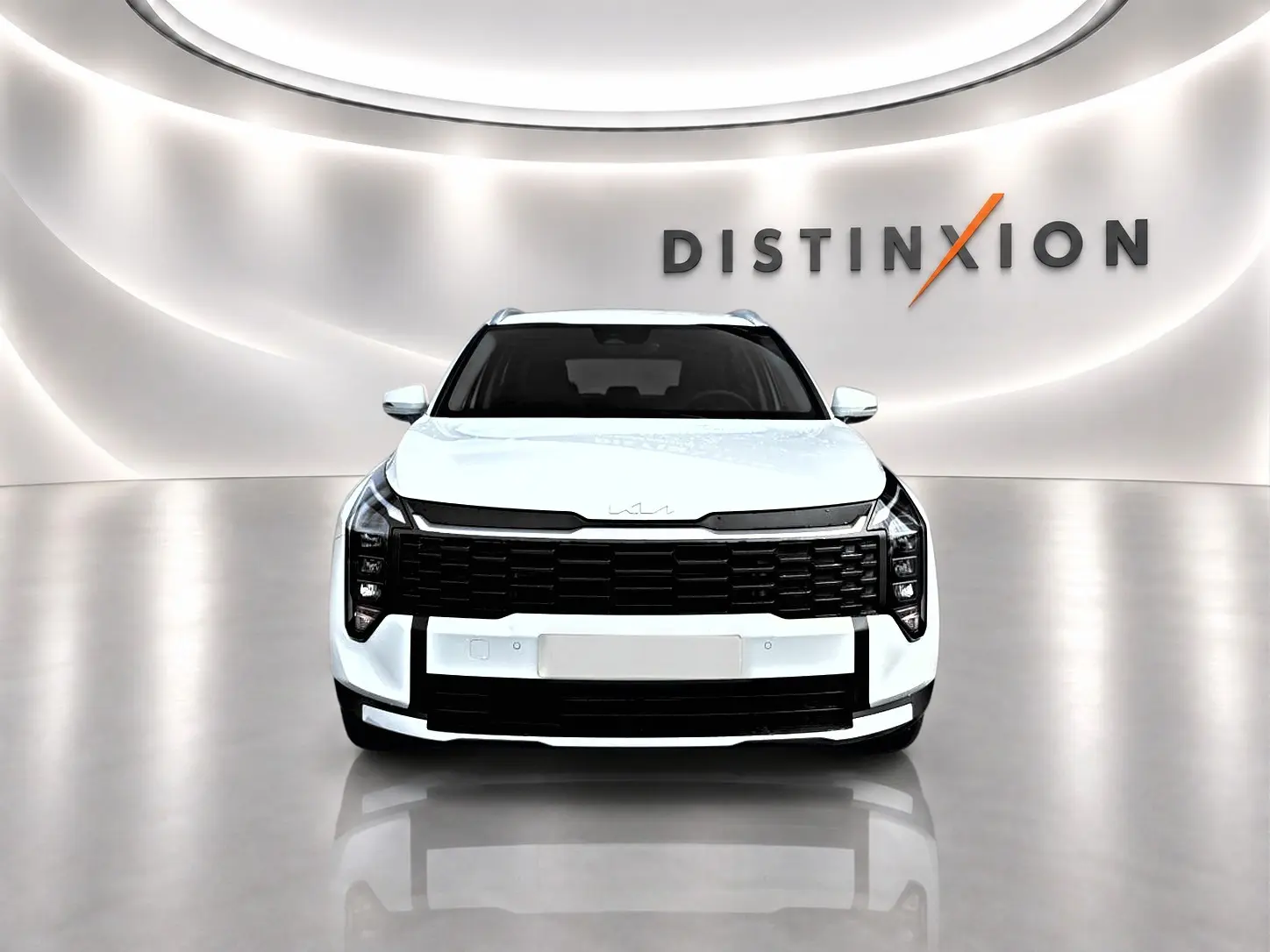 Vue frontale d'un KIA Sportage blanc 2026 avec calandre noire et logo moderne sur capot, en studio lumineux.