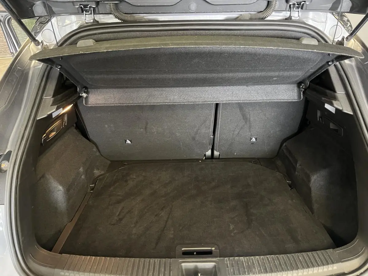 Coffre ouvert du Renault Austral gris, vue de l'arrière montrant le plancher et la banquette arrière rabattue.