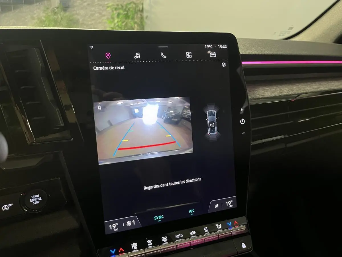 Écran central du Renault Austral 2023 affichant la caméra de recul avec ambiance lumineuse rose sur la planche de bord.