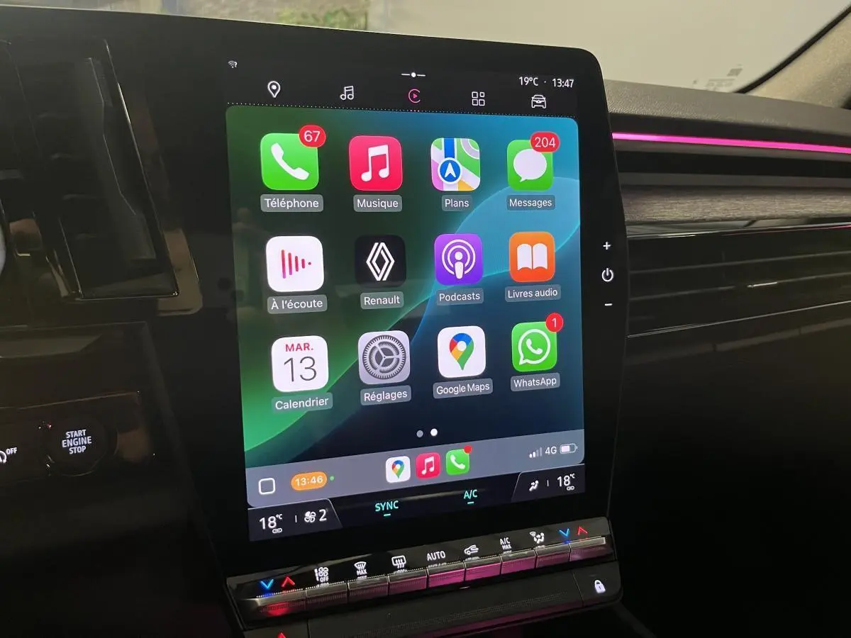 Écran tactile central du Renault Austral 2023 avec interface Apple CarPlay et ambiance lumineuse rose sur tableau de bord.