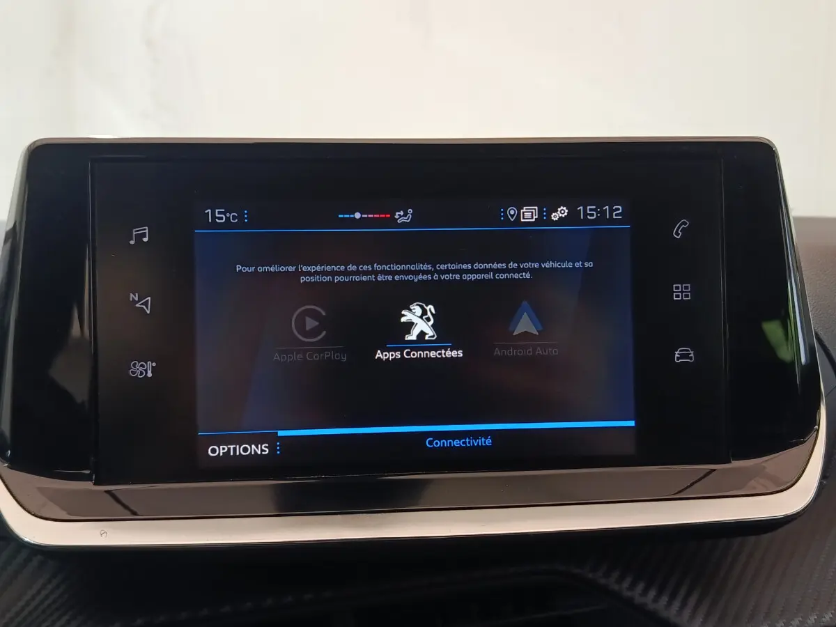 Écran tactile central de 7 pouces du tableau de bord de la Peugeot 208 PureTech blanche, affichant les apps connectées.