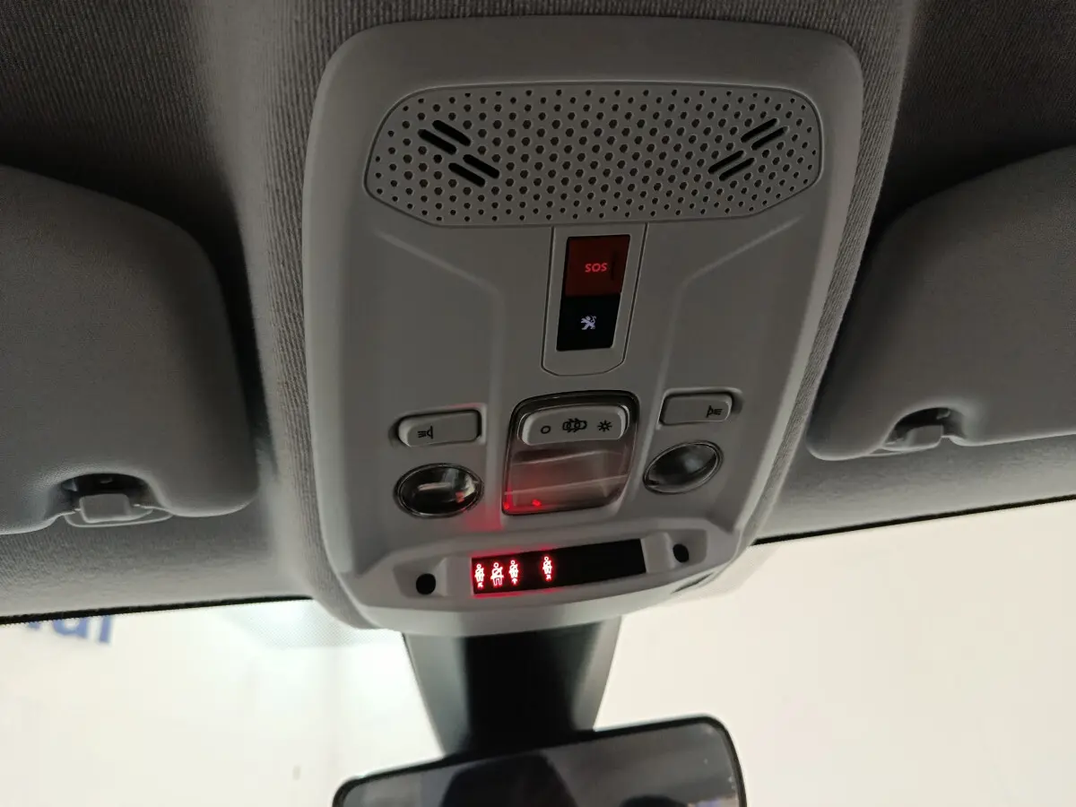 Vue en contre-plongée du plafonnier gris clair avec commandes SOS et éclairage intérieur du Peugeot 208 blanc de 2020