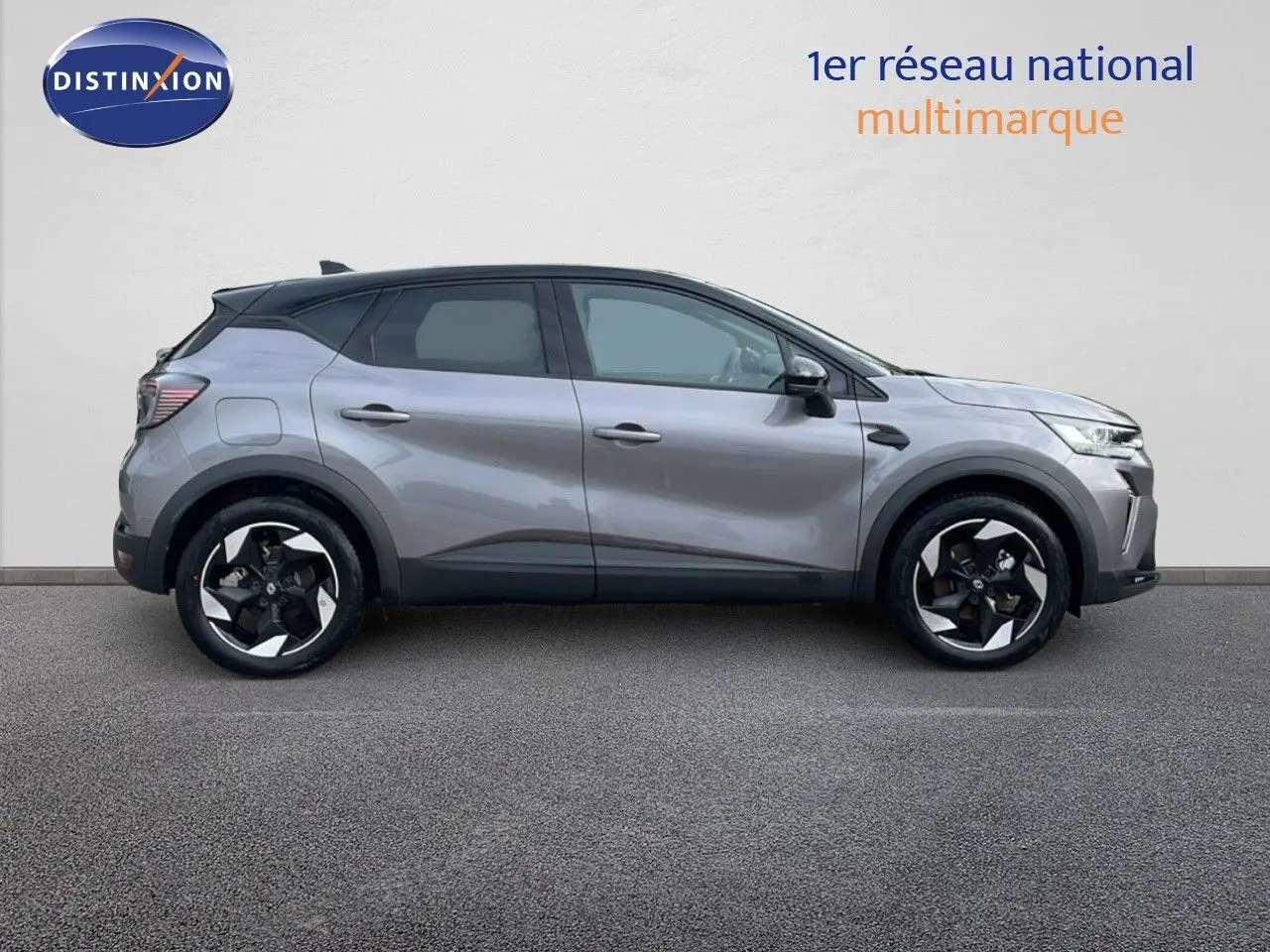 Profil droit du Renault Captur E-Tech hybride gris Cassiopée avec toit noir et jantes bi-ton 18 pouces.