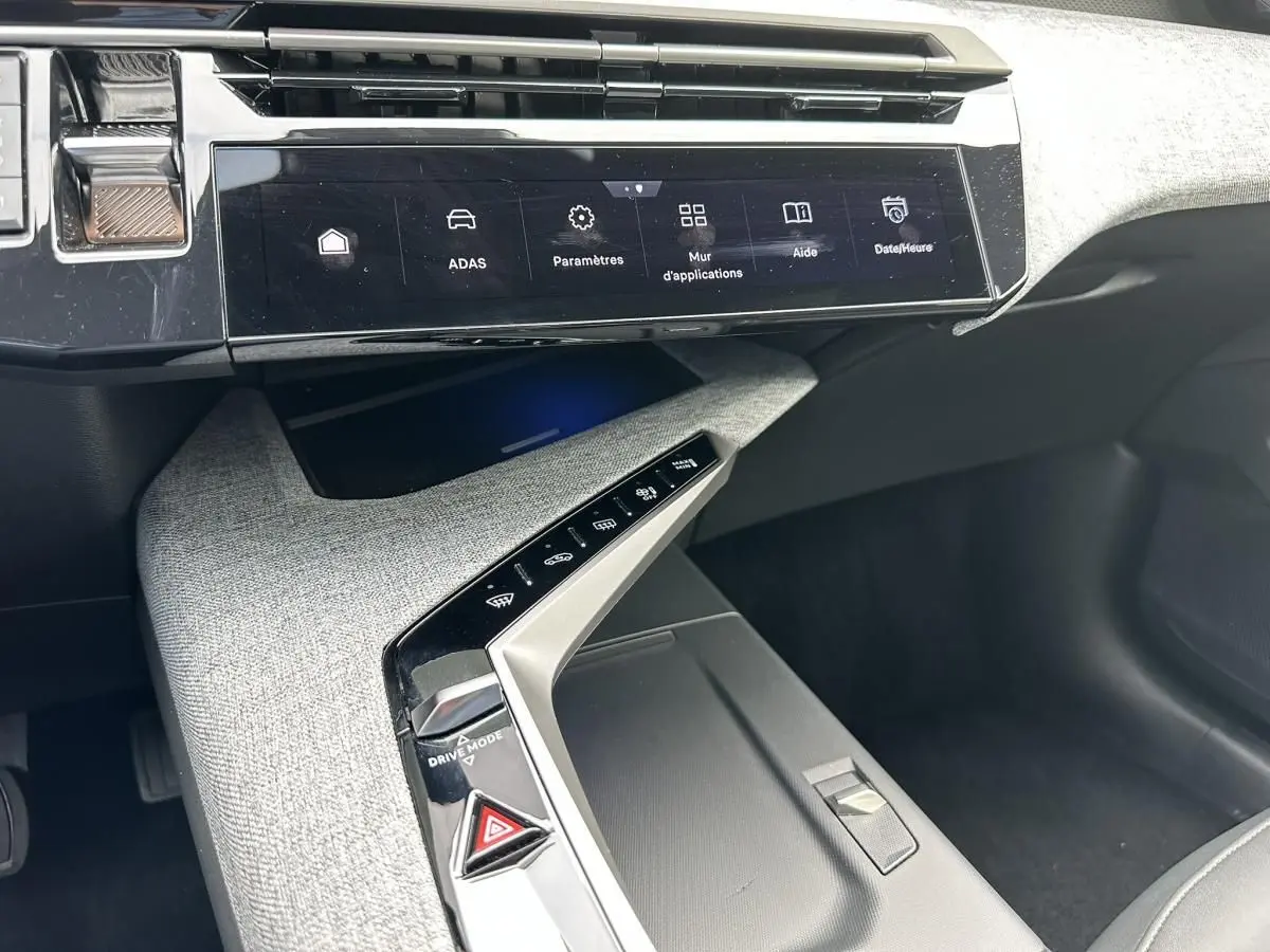 Vue rapprochée de la console centrale et écran tactile du Peugeot 3008 gris Artense, version hybride 2024.