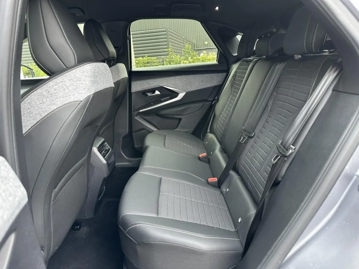Vue intérieure côté droit des sièges arrière en tissu et cuir noir du Peugeot 3008 gris Artense 2024, avec ceintures et appuie-têtes.