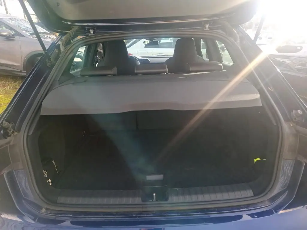 Vue arrière du coffre ouvert d'une Audi A3 2.0 TDI 150 S-TRONIC S-Line bleu, avec cache-bagages en place.