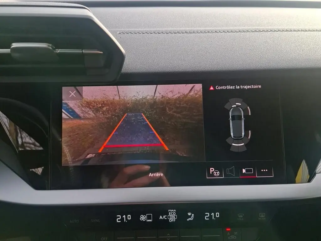 Vue intérieure du tableau de bord de l'Audi A3 bleu 2022, avec affichage caméra de recul et capteurs de stationnement.