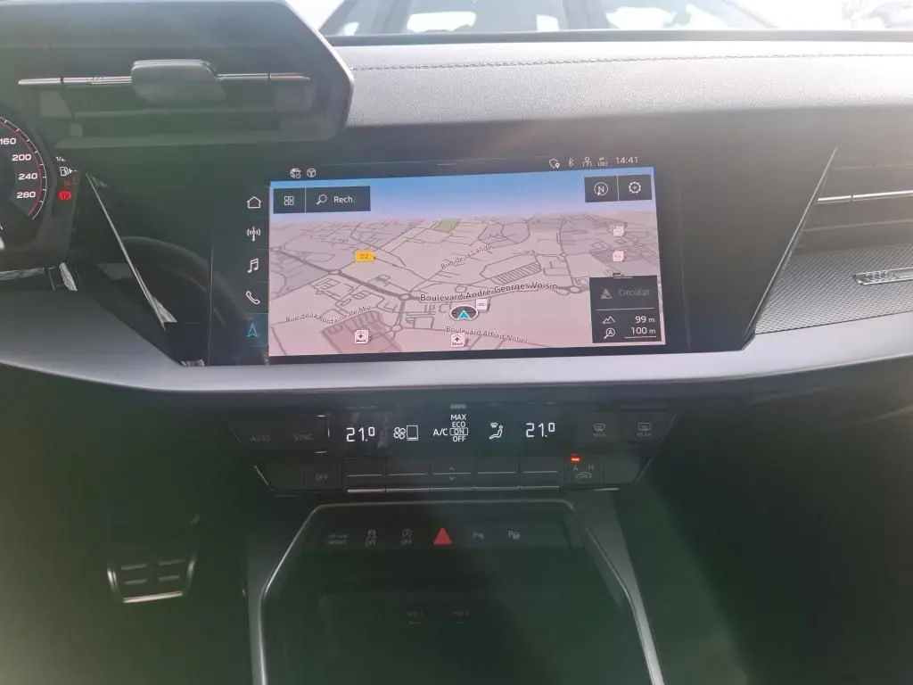 Vue rapprochée de l’écran central tactile et de la console de climatisation dans l’habitacle noir de l’Audi A3 bleu 2022.