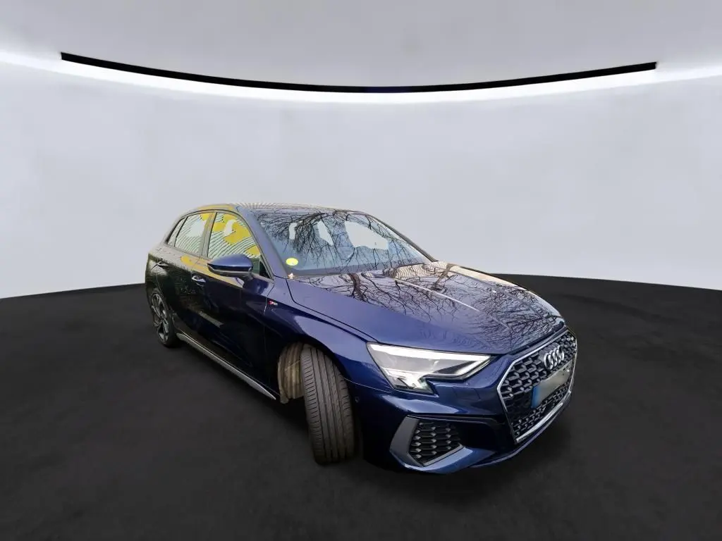 Audi A3 2.0 TDI S-Line bleu en 3/4 avant droit, avec calandre hexagonale et phares LED distinctifs.