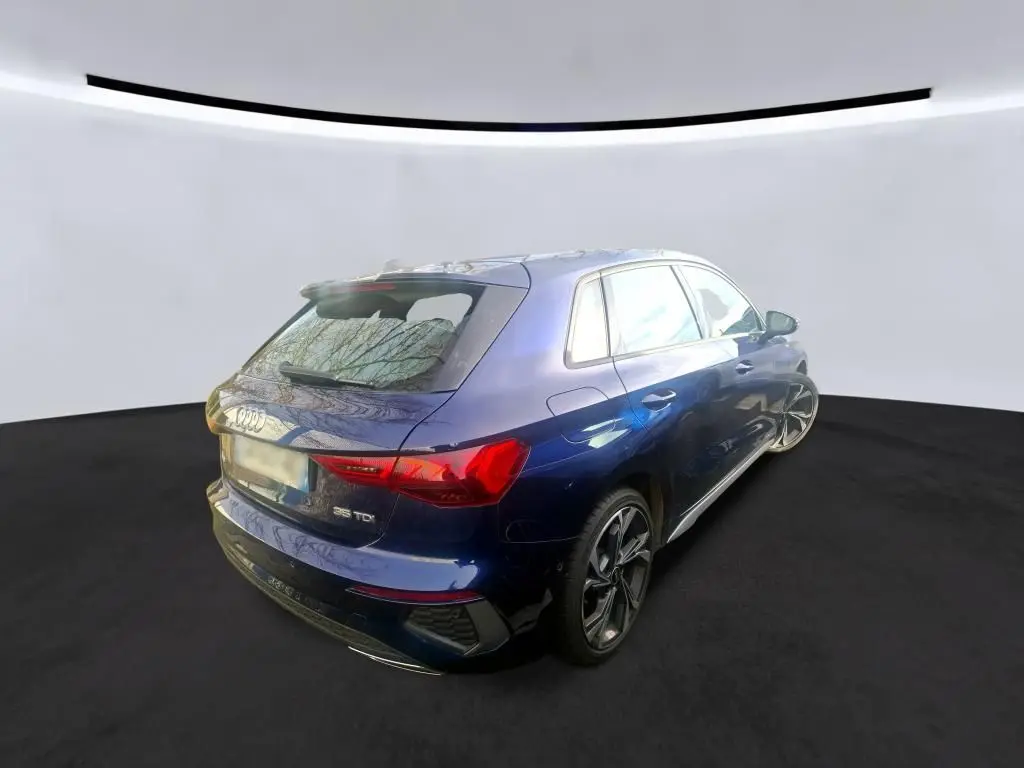 Audi A3 2.0 TDI S-Line bleu vue 3/4 arrière droit, avec jantes sport et feux arrière LED distinctifs.