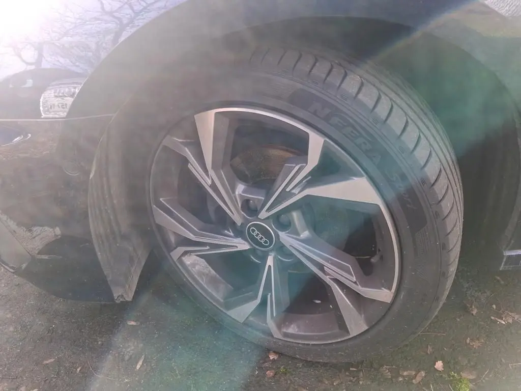 Gros plan sur la roue avant gauche d'une Audi A3 bleu 2.0 TDI 150 S-Line avec jante alliage au design moderne.