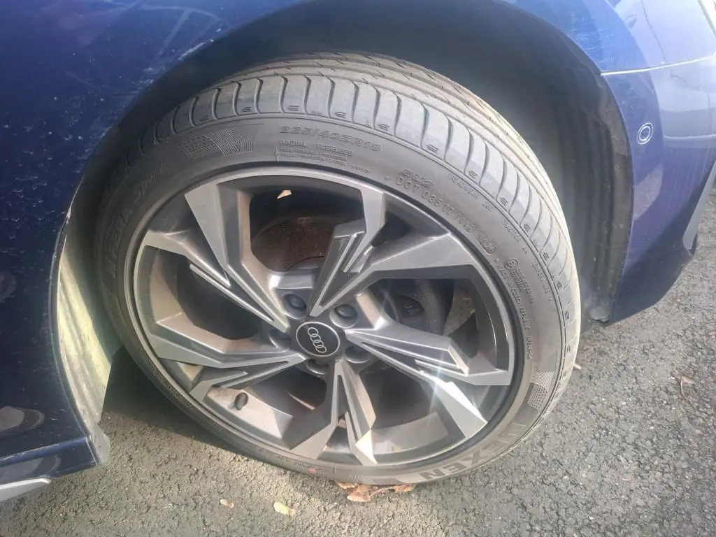 Gros plan sur la roue avant gauche d'une Audi A3 bleu 2.0 TDI 150 S-Tronic S-Line avec jante alliage distinctive.