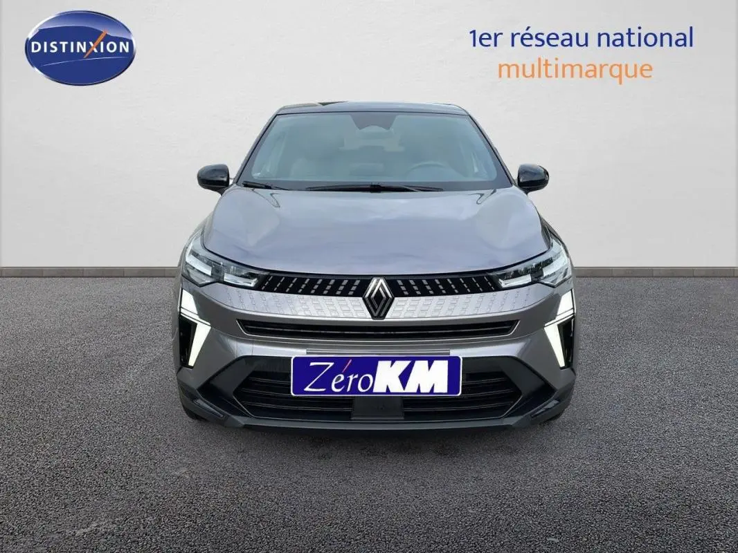 Vue frontale du Renault Captur gris 2025 avec calandre moderne et feux LED allumés sur fond neutre.