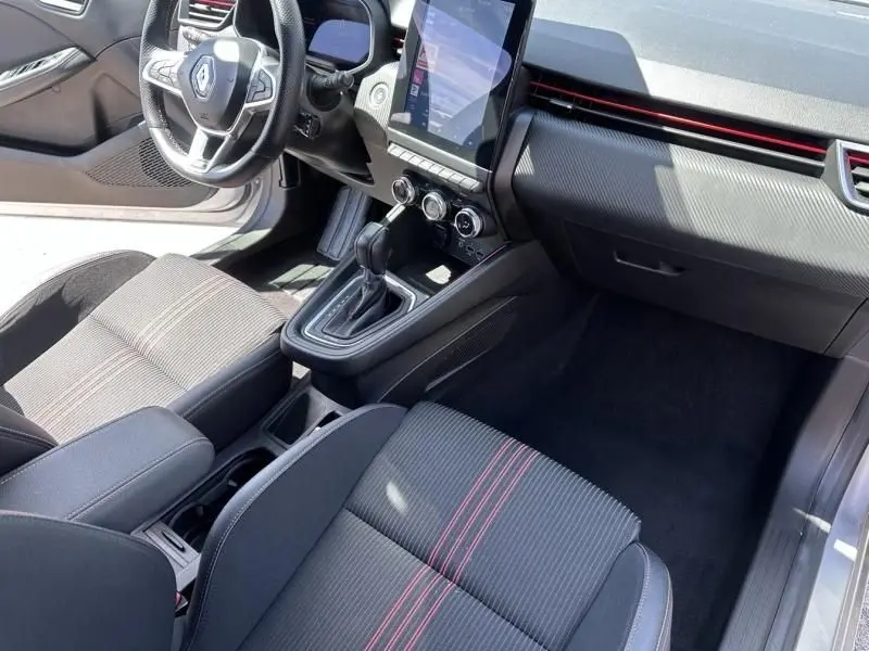 Vue intérieure côté conducteur de la Renault Clio V 1.6 E-Tech hybride gris métal, avec tableau de bord et console centrale RS Line.