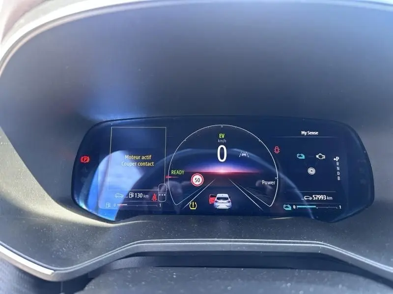 Tableau de bord numérique de Renault Clio V hybride 2022, affichage vitesse, autonomie et alertes, vue frontale rapprochée.