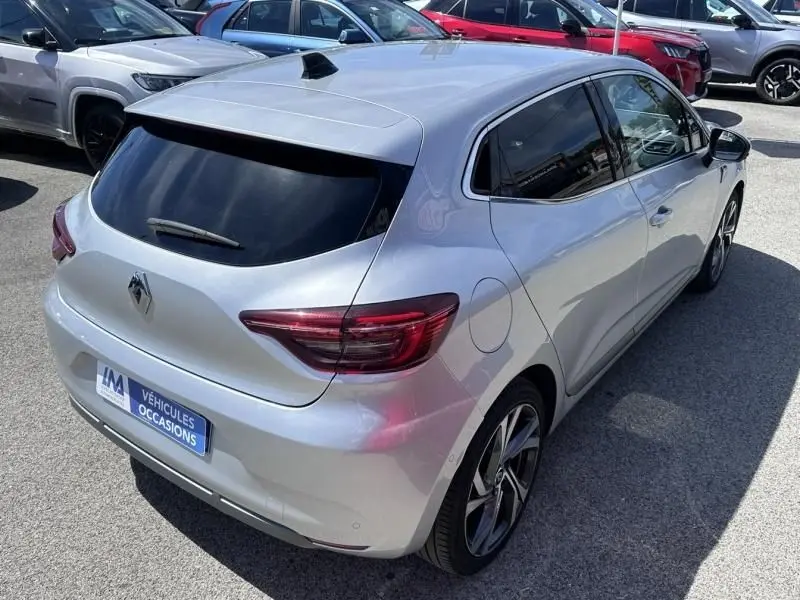 Vue 3/4 arrière droite d'une Renault Clio V gris métal 2022, finition RS Line avec vitres teintées et jantes sport.