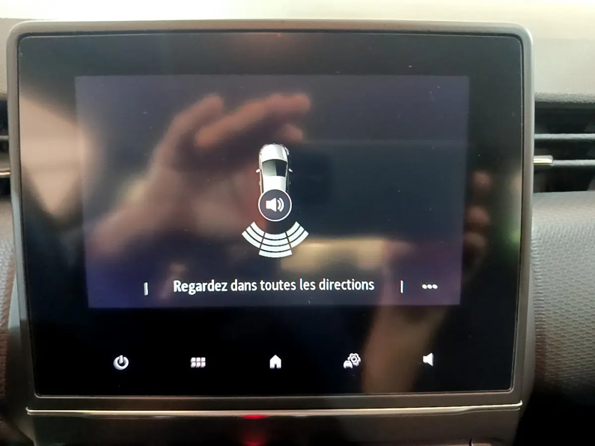 Écran tactile central de la Renault Clio Business blanc 2021 affichant l'alerte de surveillance des alentours.