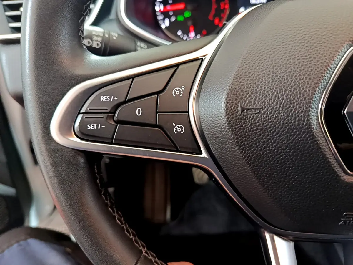 Gros plan sur le volant cuir noir de la Renault Clio Business 2021, avec commandes de régulateur de vitesse côté gauche.