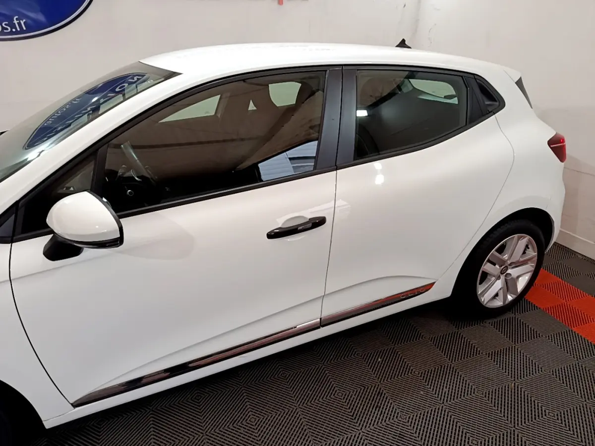 Profil côté gauche d'une Renault Clio Business blanche, mettant en valeur la ligne épurée et les jantes alliage.