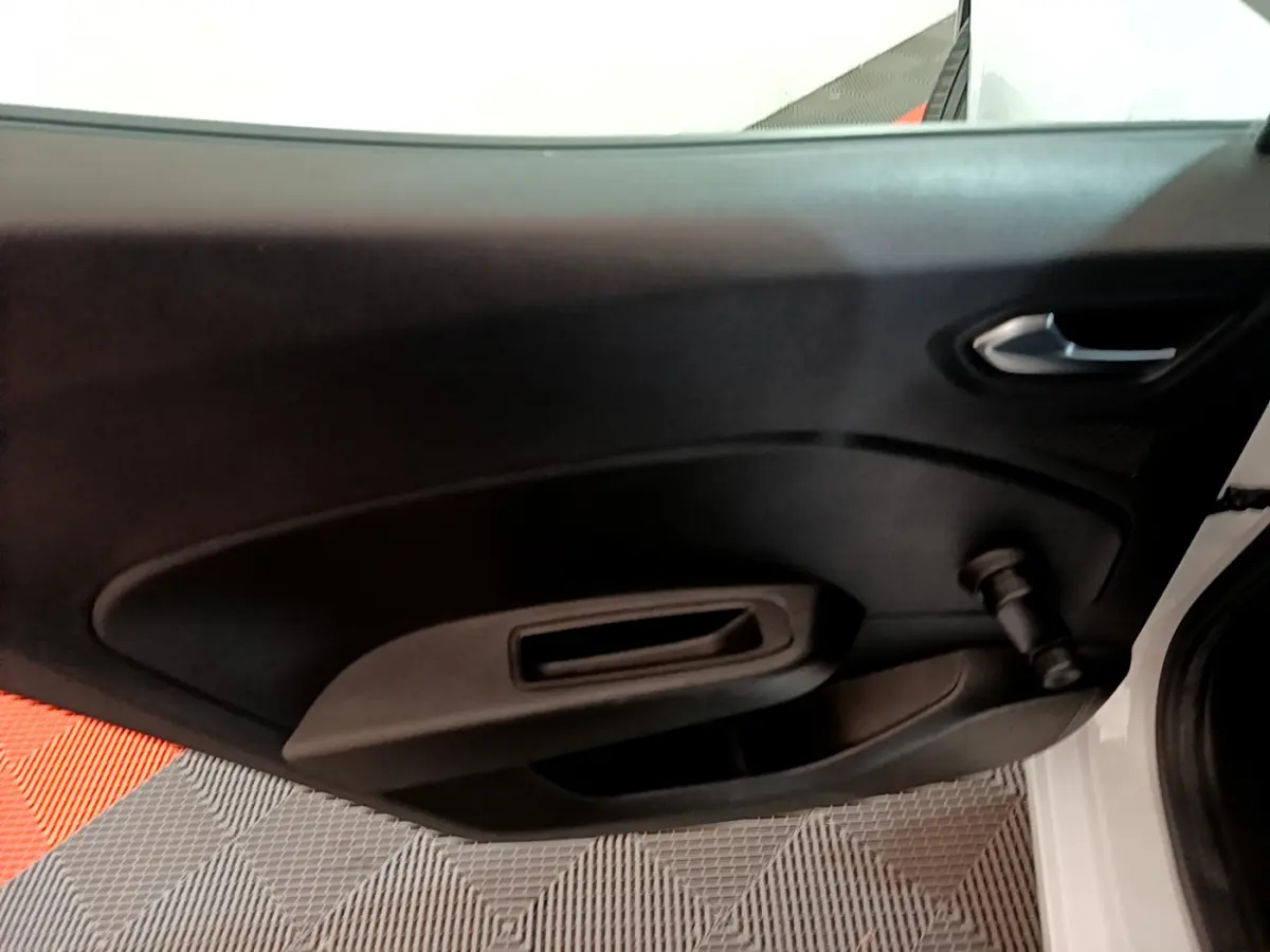 Intérieur de la porte côté gauche d'une Renault Clio Business blanche, avec poignée et manivelle de vitre manuelle.