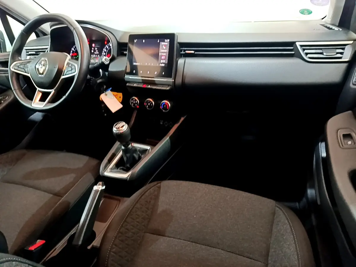Intérieur de Renault Clio Business 2021 vu côté conducteur, tableau de bord noir avec écran tactile et volant cuir.