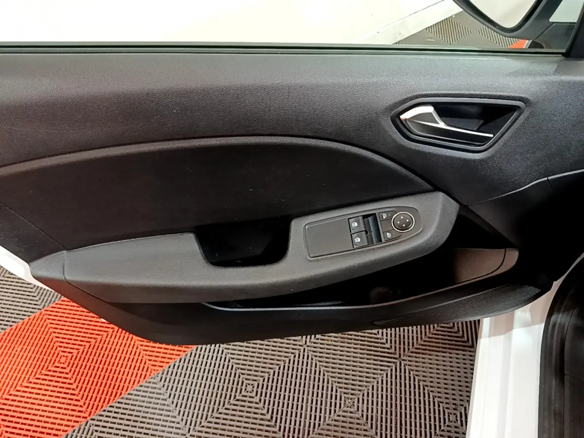 Vue rapprochée de la porte avant gauche noire de la Renault Clio Business blanche, avec commandes électriques des vitres et rétroviseurs.